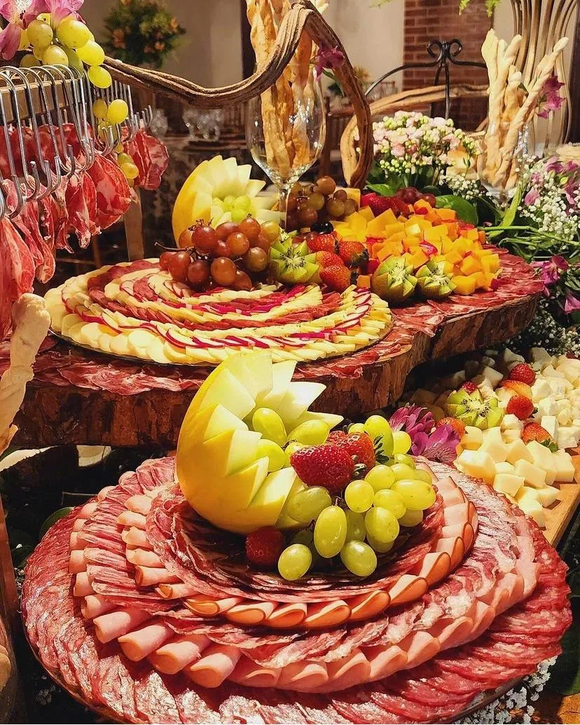 Mesa colorida de frios em rosáceas com frutas esculpidas