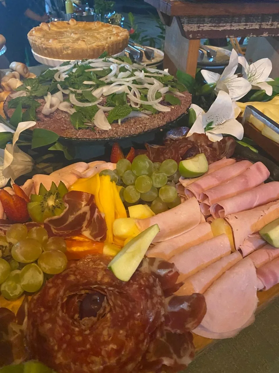 Frios fatiados com uvas e flores