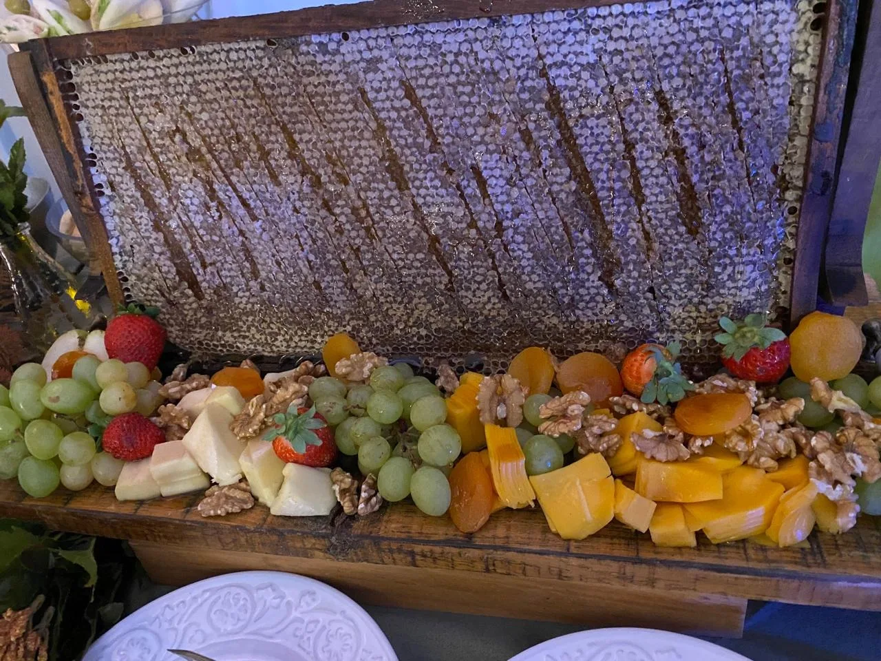Mesa de frios com frutas, queijos e favo de mel