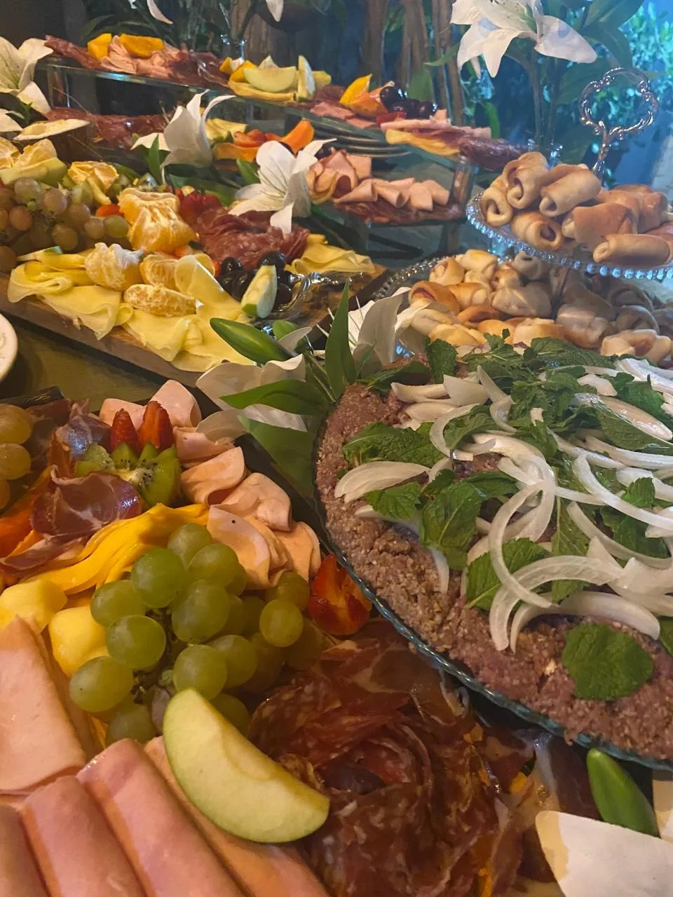 Mesa gastronômica com saladas, frios e frutas